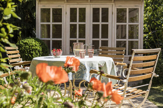 Sedie e tavolo apparecchiati in cortile primaverile — Foto stock
