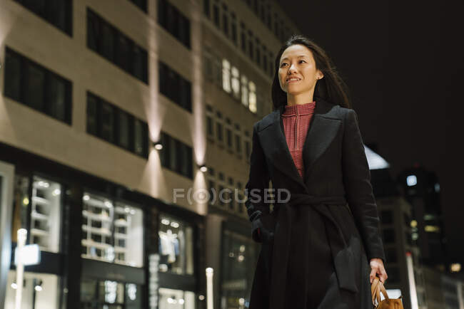 Молодая женщина, гуляющая по городу ночью, Франкфурт, Германия — стоковое фото