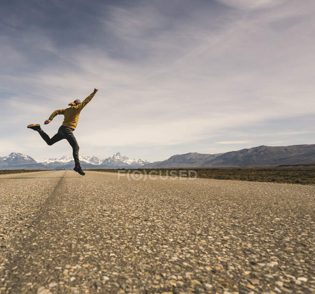 Mann springt in abgelegener Landschaft in Patagonien, Argentinien, auf eine Straße — Stockfoto