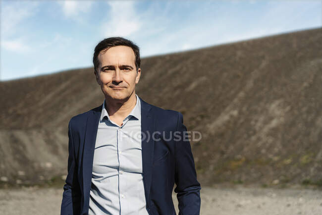Portrait d'un homme d'affaires mature confiant sur une pointe de mine désaffectée — Photo de stock
