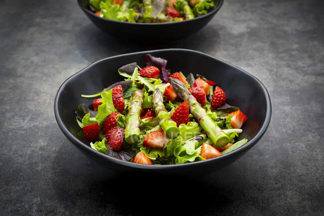 Bowl of vegetarian salad with lettuce, strawberries and asparagus — Stock Photo