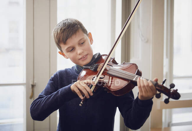 Niño tocando el violín durante una lección - foto de stock