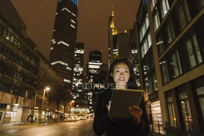Retrato de uma jovem mulher na cidade à noite, Frankfurt, Alemanha — Fotografia de Stock