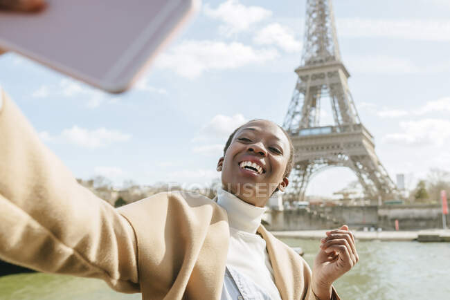 Счастливая женщина, делающая селфи на фоне Эйфелевой башни, Париж, Франция — стоковое фото