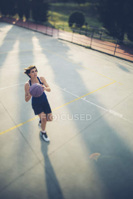 Giocatore adolescente che spara al campo da basket — Foto stock