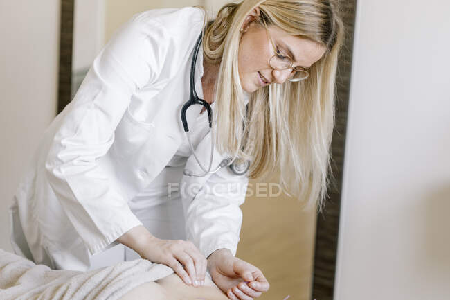 Acupuntura, trabajador sanitario alternativo con aguja de acupuntura durante el tratamiento en la espalda - foto de stock