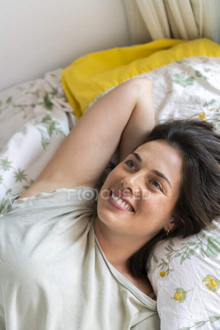 Усміхнена жінка відпочиває у спальні. — стокове фото