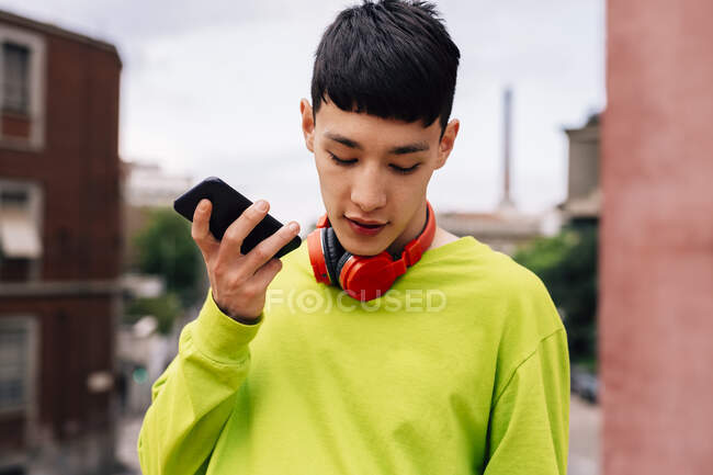 Primo piano del giovane che parla con lo smart phone mentre si trova in città — Foto stock