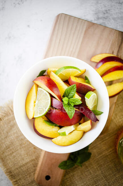 Фруктовый салат с персиком, лаймом и мятой — стоковое фото