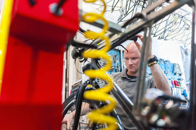 Веломеханик работает в магазине велосипедов — стоковое фото