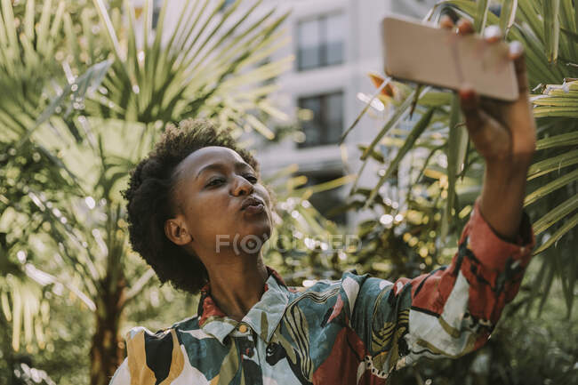 Porträt einer jungen Frau beim Selfie mit dem Smartphone im Garten — Stockfoto