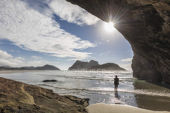 Nuova Zelanda, Isola del Sud, Tasmania, turista in grotta sulla spiaggia di Wharariki — Foto stock