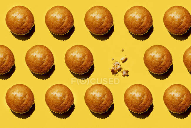 Modello di file di muffin sullo sfondo giallo con uno solo mancante — Foto stock