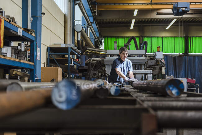Man working with metal bars in a factory — Stock Photo