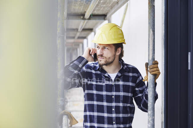 Trabalhador ao telefone um canteiro de obras — Fotografia de Stock