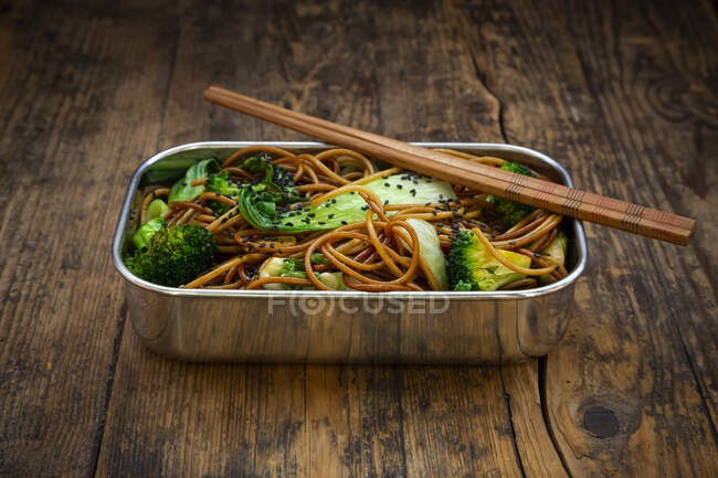 Lunch box of soba noodles with bok choy, broccoli, soy sauce and black sesame seeds — Stock Photo