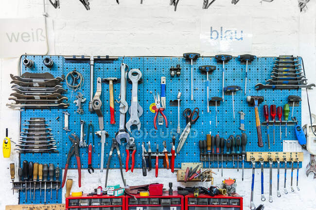 Tienda de bicicletas, pared con varias herramientas - foto de stock