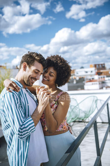 Happy multi-ethnic couple dancing on penthouse patio — Stock Photo