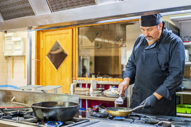 Chef avec poêle dans la cuisine traditionnelle espagnole restaurant — Photo de stock