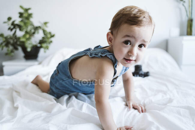Малышка ползает по кровати — стоковое фото