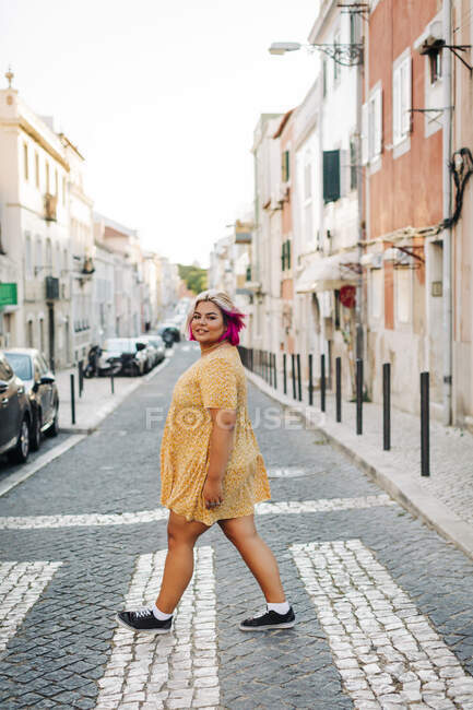 Cuerpo joven mujer positiva cruzando la calle en la ciudad - foto de stock