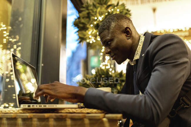 Giovane uomo d'affari che lavora su laptop in una caffetteria — Foto stock