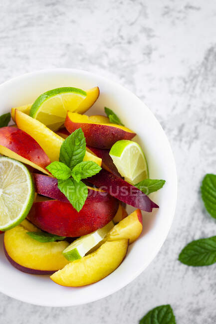 Fruit salad with peach, lime and mint — Stock Photo