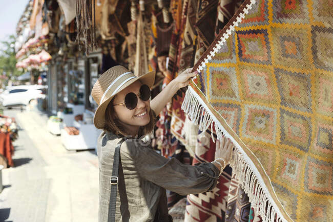 Giovane donna sorridente che compra scialle al mercato di Goreme, Cappadocia, Turchia — Foto stock