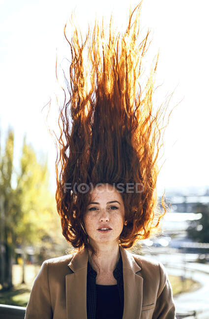 Donna sicura di sé con i capelli rossi volanti durante la giornata di sole — Foto stock