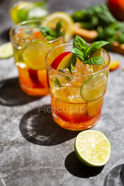 Cocktail aux pêches, menthe et citron vert et glaçons — Photo de stock