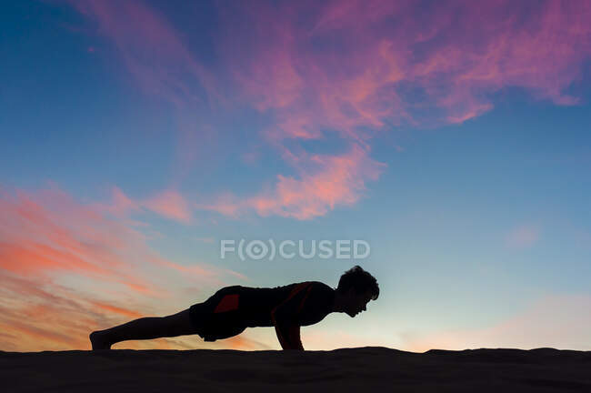 Silhouette of man doing push-ups at sunset, Gran Canaria, Spain — Stock Photo