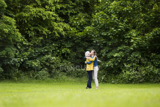 Donna anziana e figlia adulta che si abbracciano in un parco — Foto stock