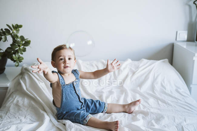 Bambina che gioca con le bolle a casa — Foto stock