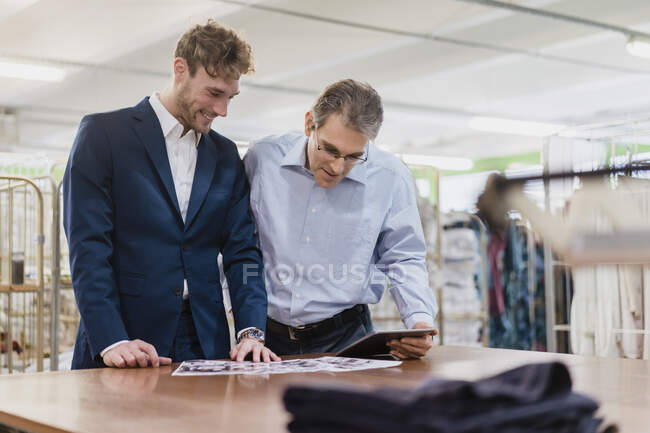 Two businessmen having a meeting in a laundry shop — Stock Photo