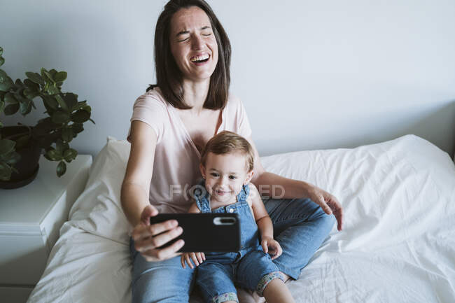 Мати і дитина дівчинка бере селфі зі смартфоном вдома — стокове фото