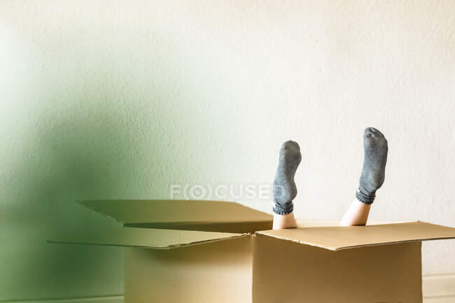 Pieds de fille à l'intérieur d'une boîte en carton — Photo de stock