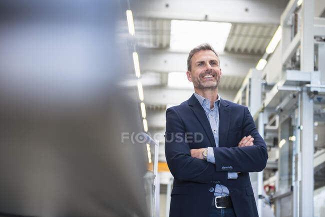 Portrait of a smiling mature businessman in a factory — Stock Photo