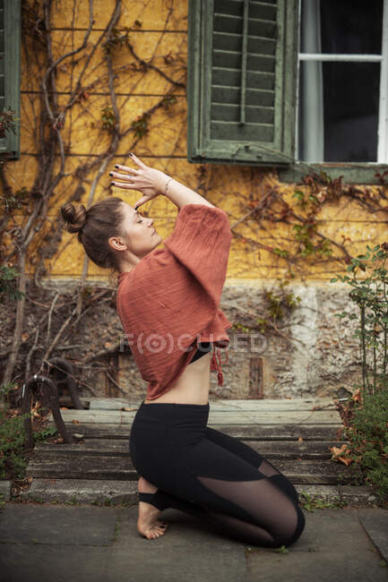 Frau praktiziert Yoga vor Mauer — Stockfoto