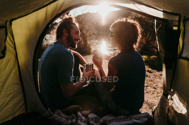 Casal feliz acampar à beira do lago — Fotografia de Stock
