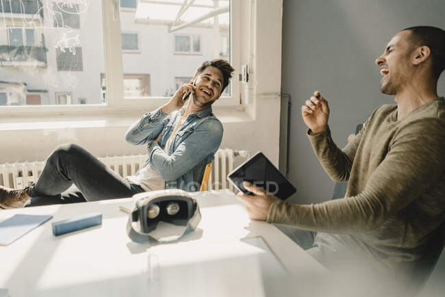 Jovens empresários que trabalham em conjunto no escritório, falando ao telefone — Fotografia de Stock