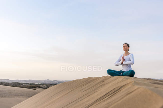Mulher praticando ioga ao pôr do sol nas dunas, Gran Canaria, Espanha — Fotografia de Stock