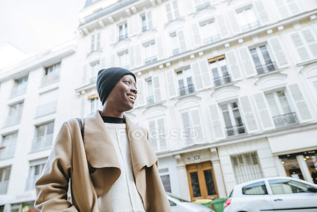 Счастливая молодая женщина против белой застройки в городе, Париж, Франция — стоковое фото