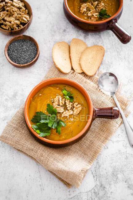 Overhead view of pumpkin soup with walnuts and parsley — Stock Photo