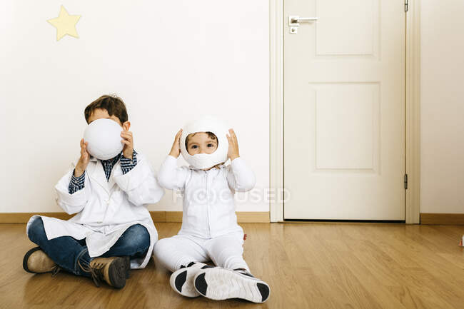 Siblings playing astronaut and researcher at rocket — Stock Photo