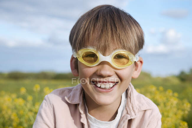 Блондин в очках для плавания на поле изнасилования в солнечный день — детство, Счастливый - Stock Photo