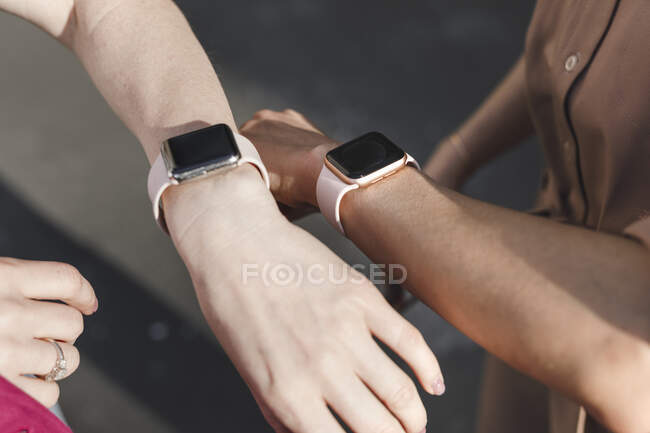 Mains de femmes d'affaires portant des montres intelligentes en plein air — Photo de stock