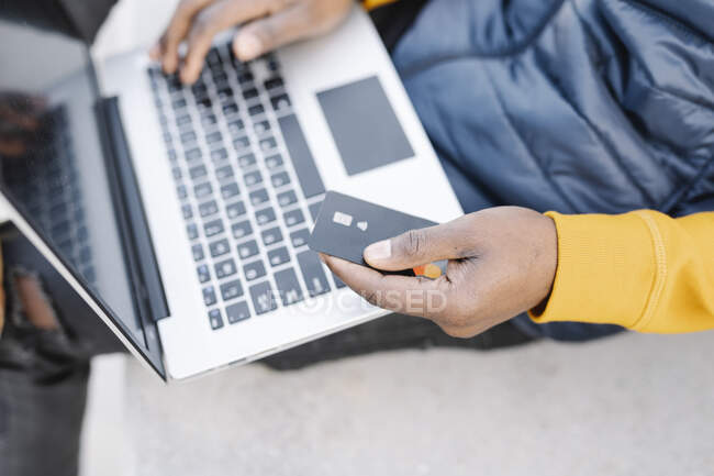 Чоловік, який використовує ноутбук і кредитну картку для онлайн-покупок. — стокове фото