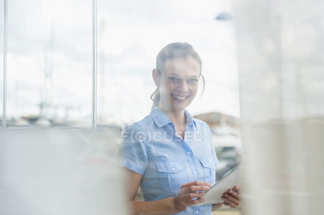 Retrato de mulher sorridente com tablet digital atrás do vidro da janela na marina, Maiorca, Espanha — Fotografia de Stock