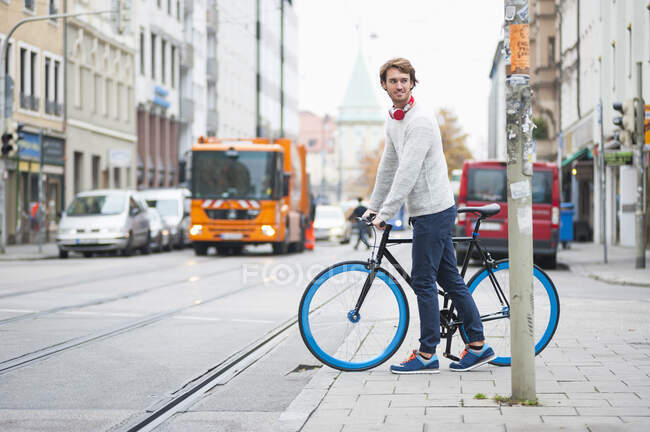 Портрет молодого человека с велосипедом в городе — стоковое фото