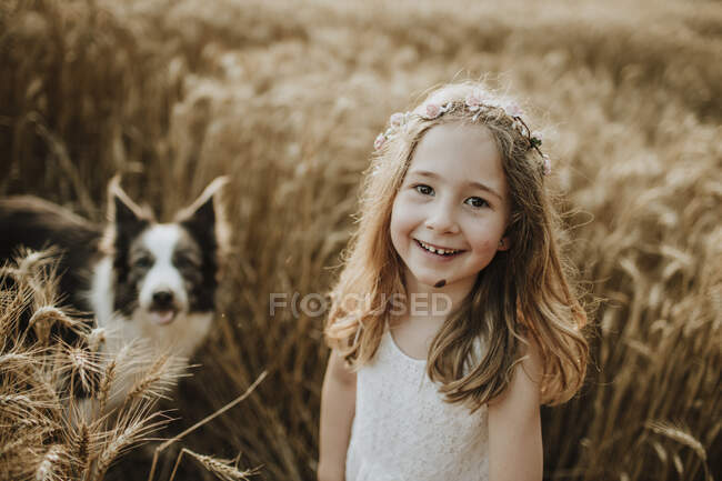 Мила посміхається дівчина з прикордонником Коллі собакою на пшеничному полі — стокове фото